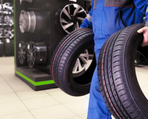 man met zomerbanden in garage