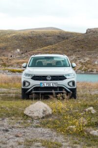 Vooraanzicht van een witte Volkswagen T-Cross SUV met Turkse nummerplaat (34 FGG 670) in een natuurlijke, rotsachtige omgeving.