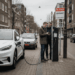 Twee mannen bij een laadpaal die problemen ervaren tijdens het opladen van een elektrische auto in een Nederlandse woonwijk.
