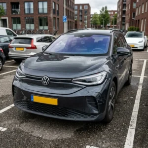 Moderne auto met lichte schade aan de voorbumper op een parkeerplaats in Nederland