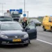 Auto met pech langs de weg terwijl bestuurder hulp belt voor pechhulp
